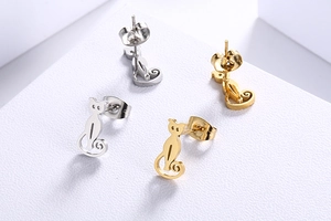 Detailed view of cat-shaped stud earrings in silver and gold stainless steel finishes
