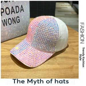 Dettaglio del cappello bianco con strass iridescenti su una superficie in legno