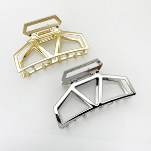 Close-up of gold and silver geometric hollow metal hair claws for thick hair