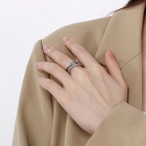 Detail of silver knot ring with sparkling crystals on double band layered structure