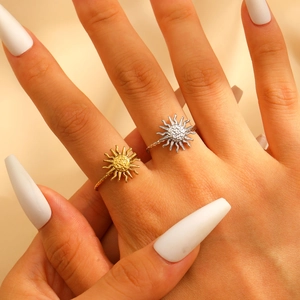 Detail of gold and silver sun-shaped stainless steel rings on silk background