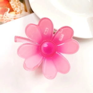 Close-up of translucent pink flower hair claw clip with matte resin finish and bead