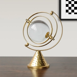 Nordic abstract gold iron ornament with a crystal ball on a modern hammered metal base