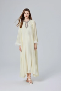 Détail de la robe plissée crème avec col en cristal et manches bordées de plumes