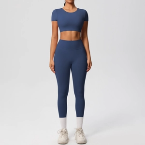 Détail d'un ensemble de yoga bleu marine avec crop top à manches courtes et legging taille haute