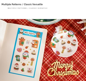 Close-up of PET transparent Christmas stickers with Santa and reindeer on a notebook