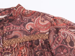 Detail of bohemian paisley chiffon blouse with lace stitching and elegant stand collar