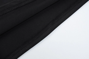 Detailed macro view of the double-stitched hem on high-quality black knit fabric dress
