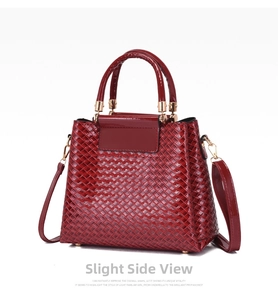 Detail of red woven texture handbag featuring gold hardware and protective metal feet