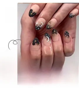 Detail of gradient black press-on nails with white moon and gold star patterns