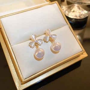 Elegant gold clover earrings featuring opal stones and hanging pearls in a jewelry gift box