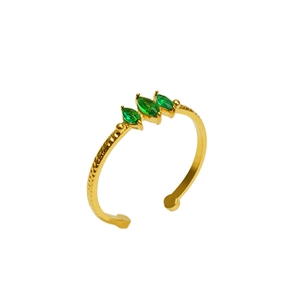 Macro d'une bague ajustable dorée ornée de trois zircons verts de coupe marquise