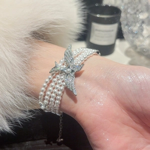Vue détaillée du bracelet de perles multicouches avec pendentif étoile en zircone et argent
