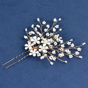 Detail of bridal hair pin with golden wire branches, white flowers and small pearls