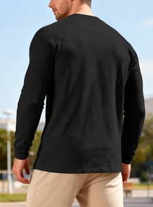Detailed back view of a black waffle knit long sleeve Henley shirt for men outdoor