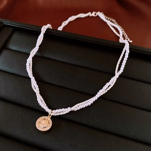 Dettaglio collana di perle a due fili con pendente a stella e zirconi su un portagioie