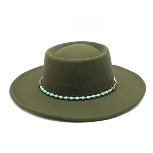 Macro detail of olive wool felt boater hat with turquoise beads and bronze metal trim