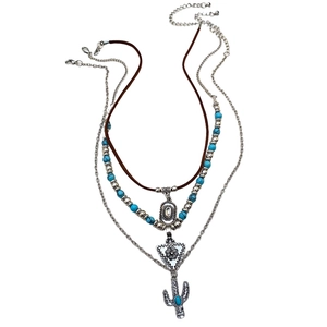 Dettaglio della collana bohémien a strati con perle turchesi e ciondolo cactus
