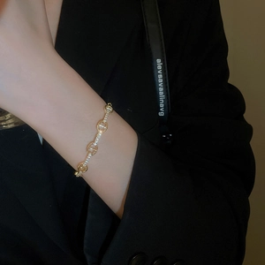 Detail shot of a gold-plated anchor chain bracelet with zircon-inlaid oval links