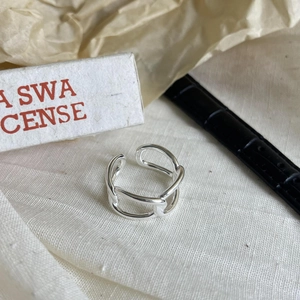 Macro view of adjustable silver interlocking chain ring on neutral background