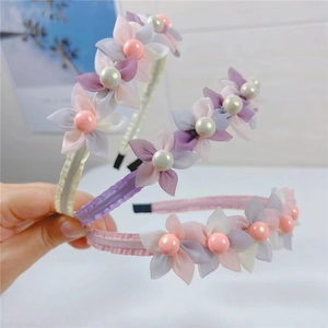 Macro view of mesh flower petals with central faux pearl details on a sweet style headband