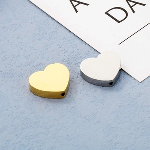 Dettaglio macro delle perline a cuore in acciaio inossidabile dorato e argento