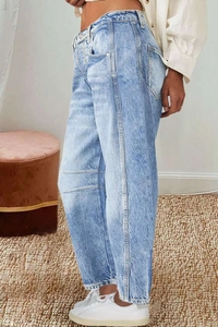 Detail of light blue washed denim jeans showing side seam stitching and straight leg fit