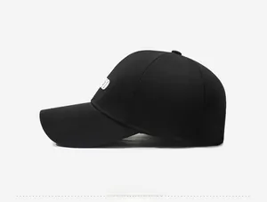 Detail view of black baseball cap featuring white side embroidery and curved brim stitching