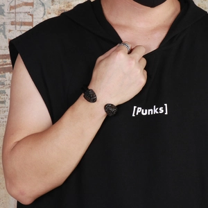 Close-up of black punk wolf head wire bracelet worn by male model on wrist
