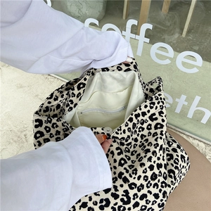 Detail view of leopard print tote bag interior with magnetic buckle and inner pockets