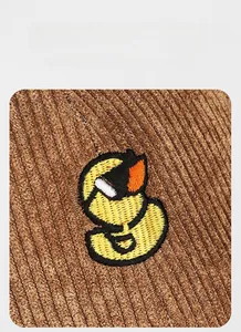 Detail of embroidered duck logo on brown corduroy fabric with high-quality texture