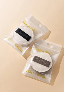 Detail of two Rubycell makeup puffs with GM logo in clear matte ziplock packaging