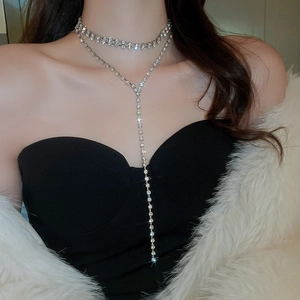 Dettaglio di collana in argento multistrato di lusso con nappe su modella elegante