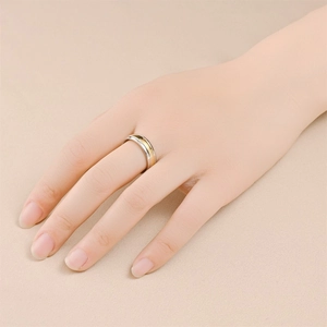 Close-up of dual-tone minimalist titanium steel ring with silver and gold matte finish