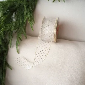 Close-up of 6cm cream velvet ribbon with gold stars for Christmas gift wrapping
