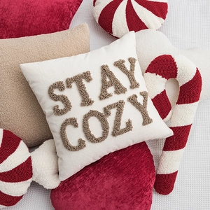 Cream Christmas pillow with brown Stay Cozy embroidery and tufted textured details