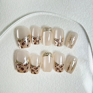 Handmade leopard print press-on nails with gold foil trim in a short square shape