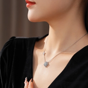 Détail du collier trèfle à quatre feuilles argenté avec gemmes porté par le mannequin