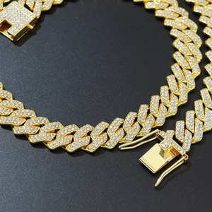 Detailed macro shot of 14mm golden Cuban link necklace with sparkling crystals