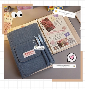 Detail of blue denim notebook with 6-ring binder, pockets and dual pen holders