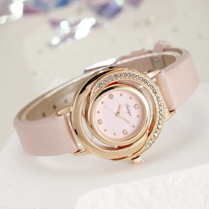 Close-up of pink leather watch with gold rhinestone case and elegant round dial