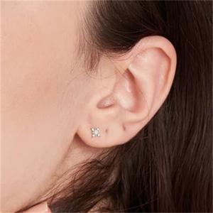 Close-up of a minimalist S925 sterling silver stud earring with clear round-cut stone