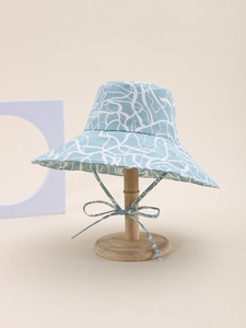 Detail of light blue reversible sun hat with abstract print and delicate chin strap
