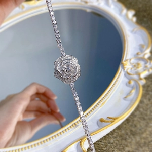Detailed view of silver camellia tennis bracelet with shimmering white zircons