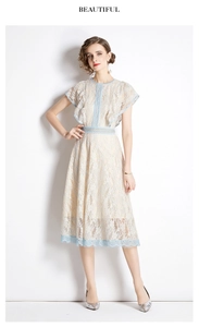 Detail of delicate beige lace dress with blue floral embroidery and ruffle sleeves