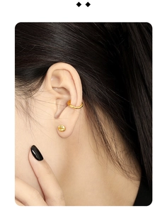 Nahaufnahme eines goldenen S925 Silber-Ohrsteckers und Earcuffs im unregelmäßigen Design