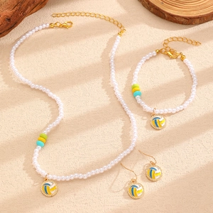 Détail de parure bijoux en perles avec breloques volleyball et chaîne dorée fine