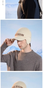 Detail of cream knit trapper hat with BOSTON embroidery and ear flaps for winter warmth