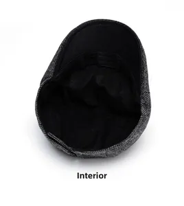 Detail view of the black lining and precise stitching inside the grey herringbone flat cap