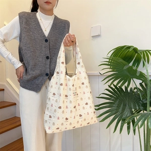 Detail of a beige quilted tote bag with cute bear patterns and textured bubble fabric